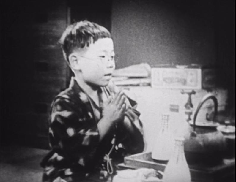 young boy in robe with hands folded in praying position