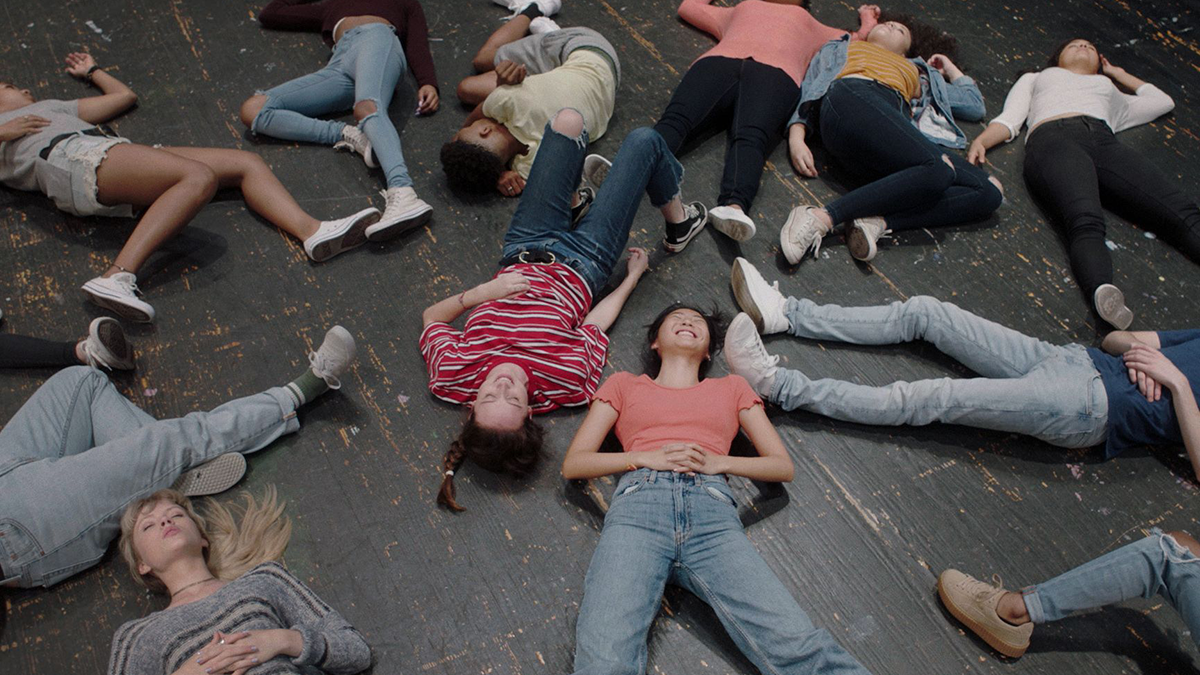 many young people lying on their backs, smiling