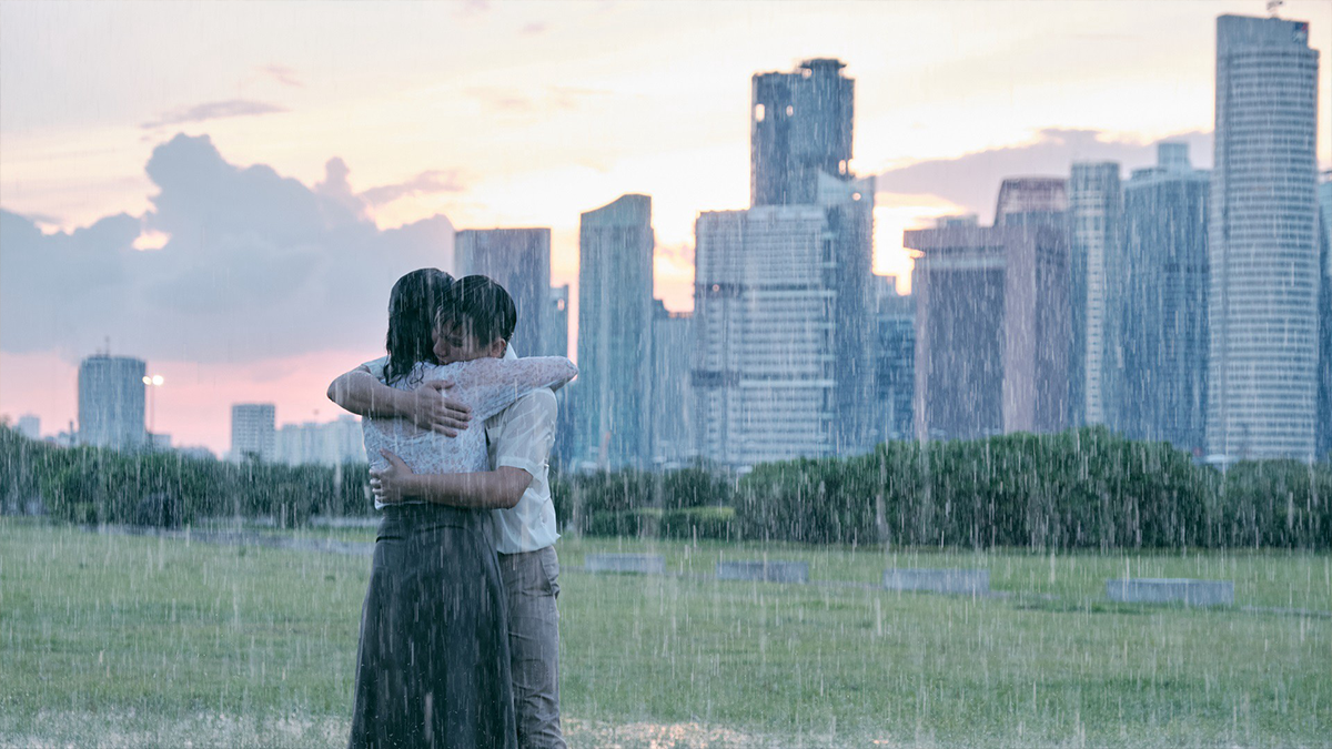 people embracing in the rain with a skyline in the background