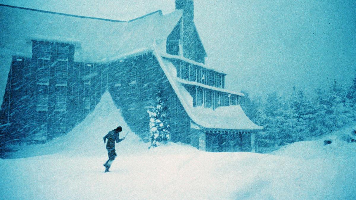 person running across snow in front of house