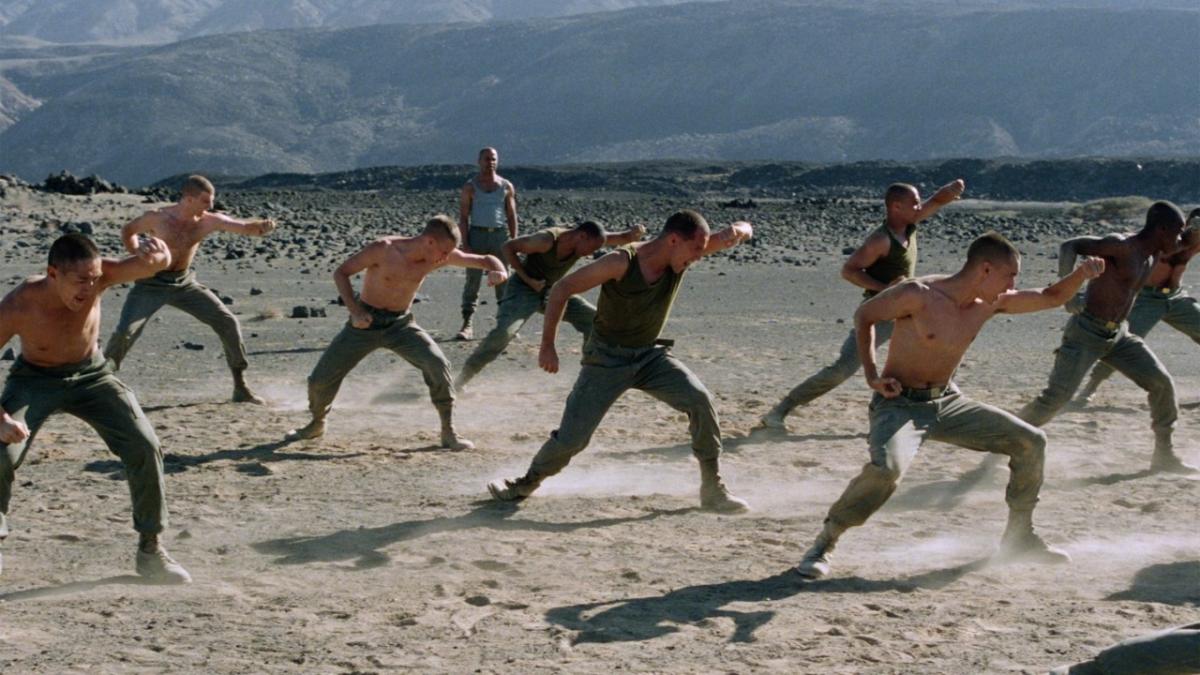 men on beach performing exercises with arms 
