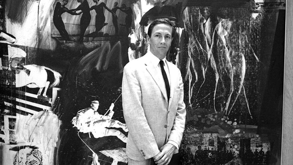 black and white photo of man in suit in front of large art