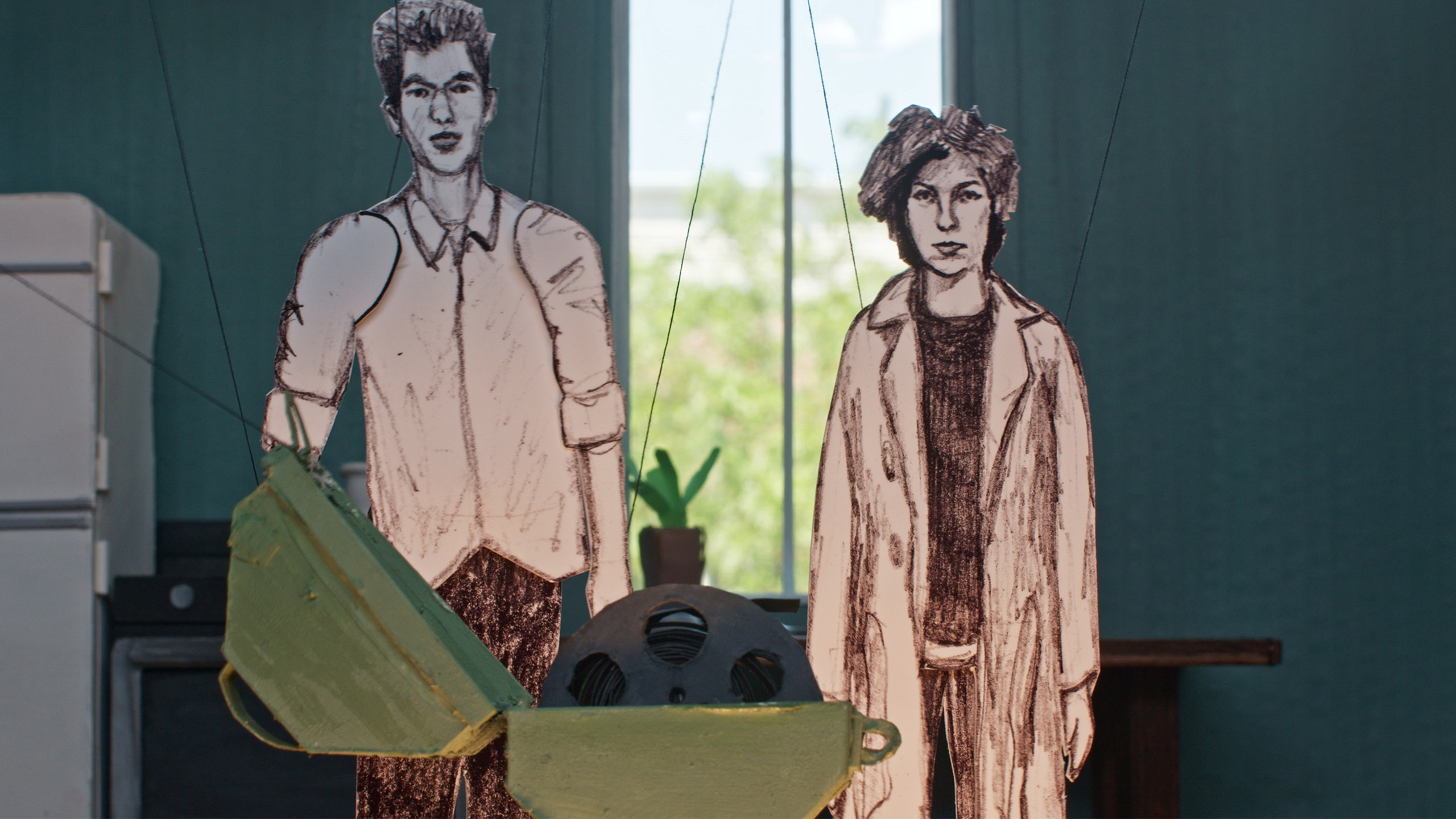 paper cut outs of two people in a room looking towards an open chest