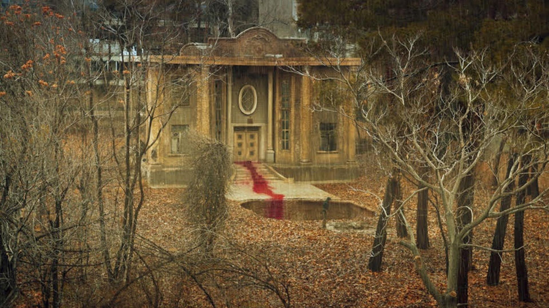 old building in woods with trail of blood at building door