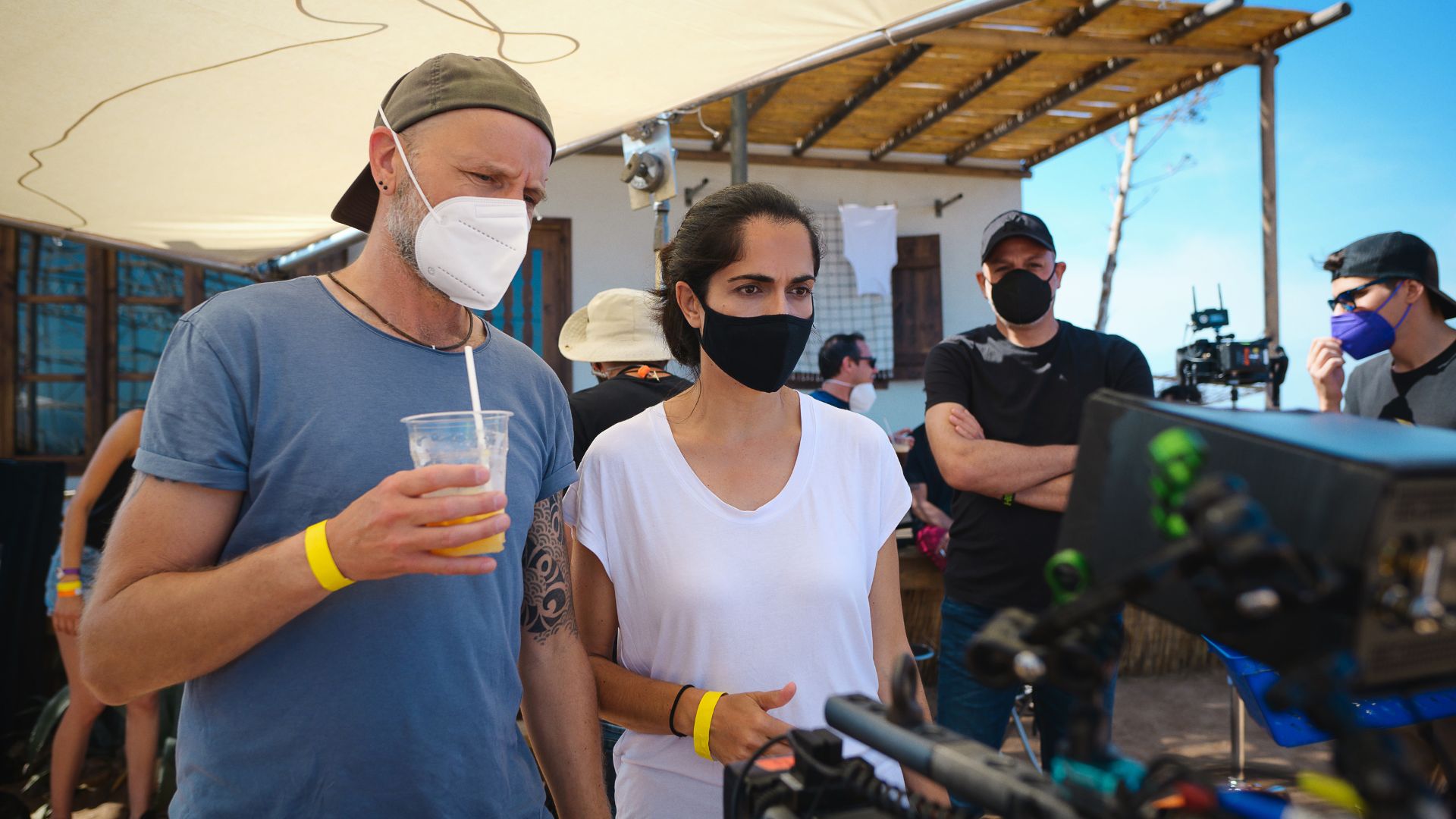 people wearing masks working on film set