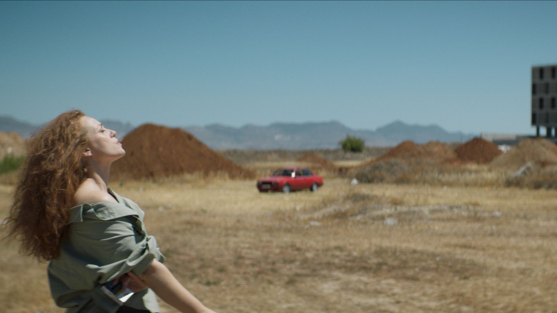DAPHNE, woman standing in desert looking up towards sky