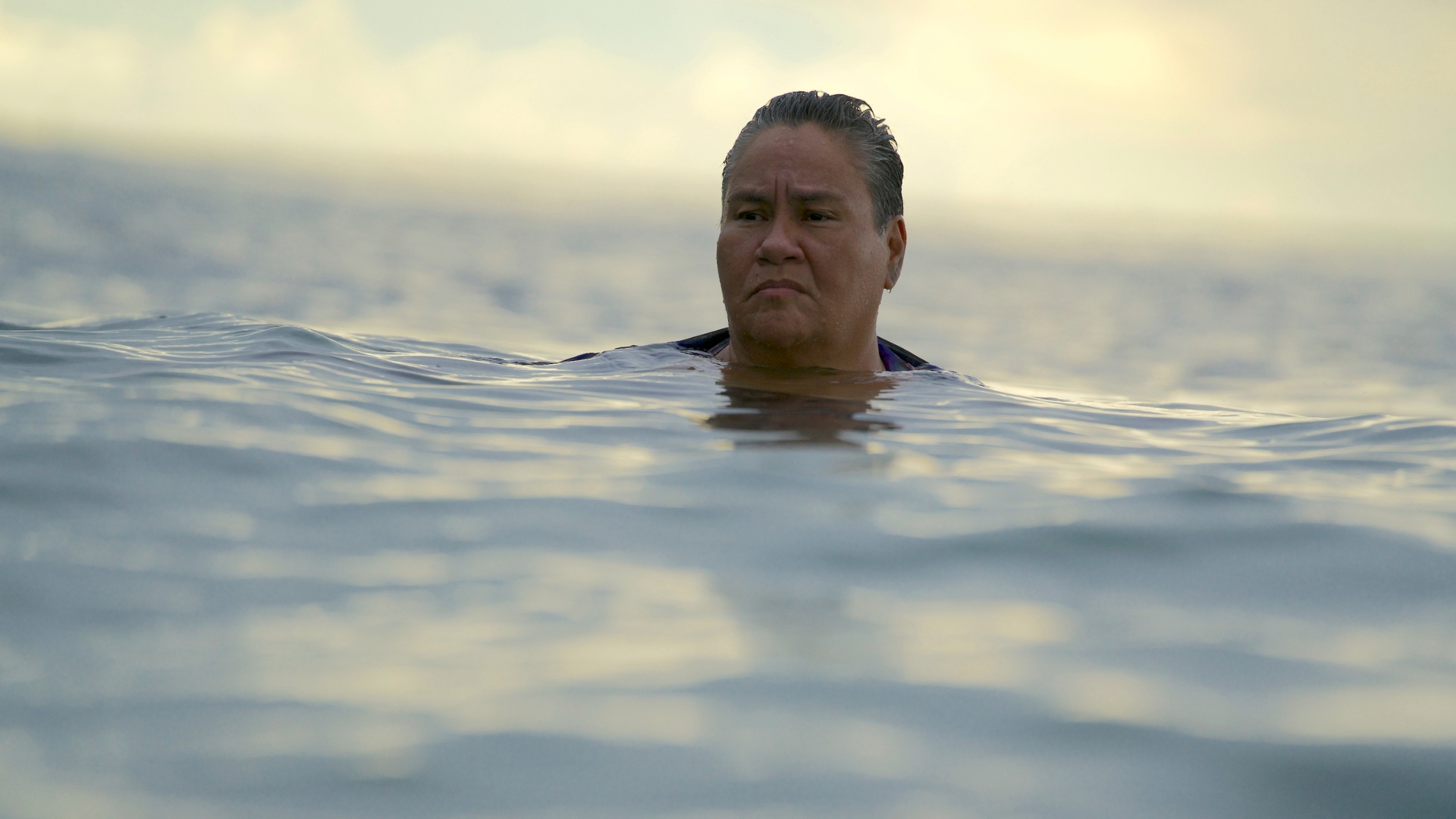 BEFORE THE MOON FALLS, 2025, man's head out of water while treading in the ocea