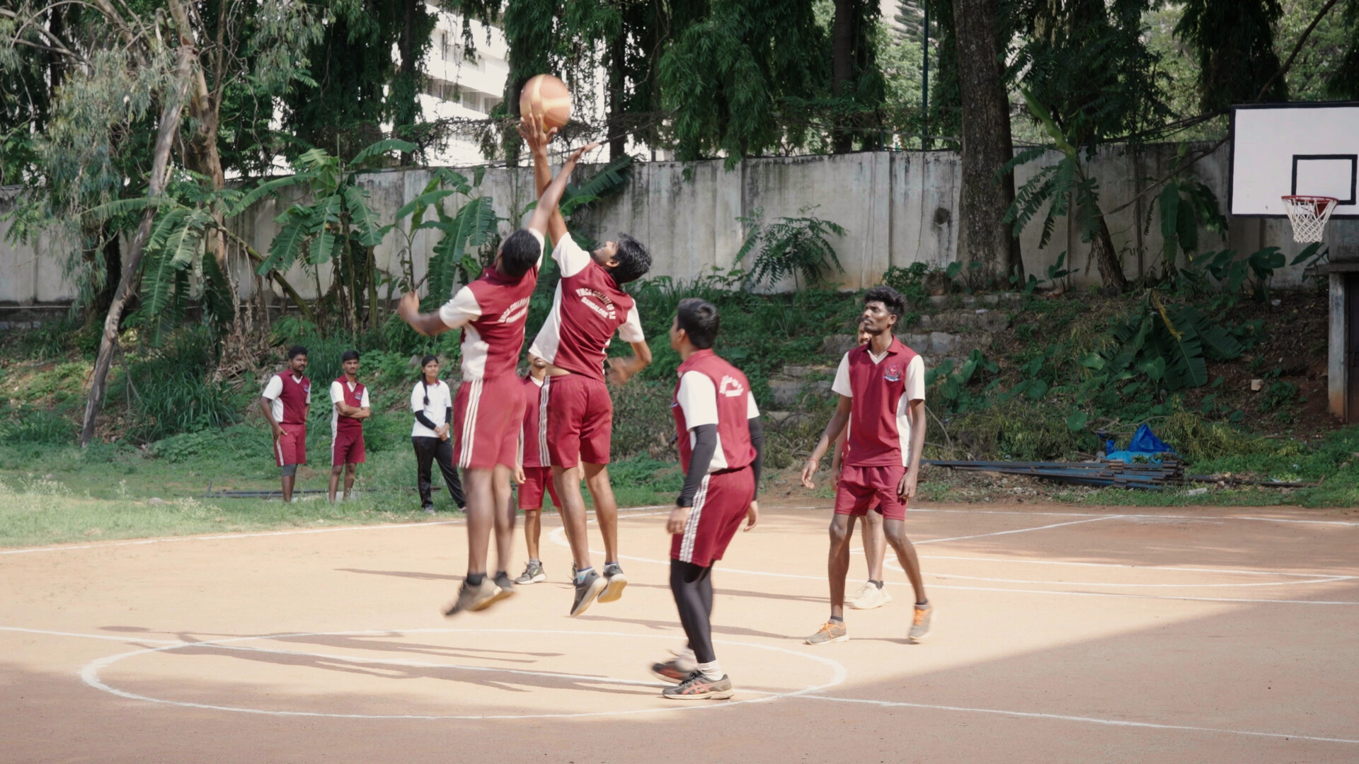 HOOP LIKE THIS, 2025, group of young boys playing basketball on outdoor court with matching red uniforms