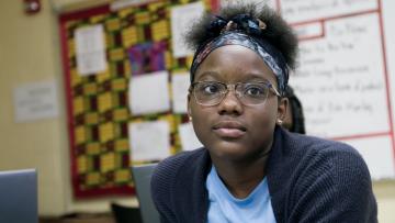 girl in school classroom looking forward