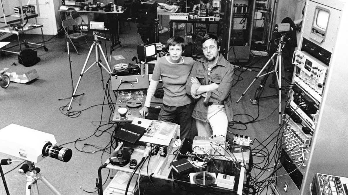 two people looking at the camera surrounded by tech gear