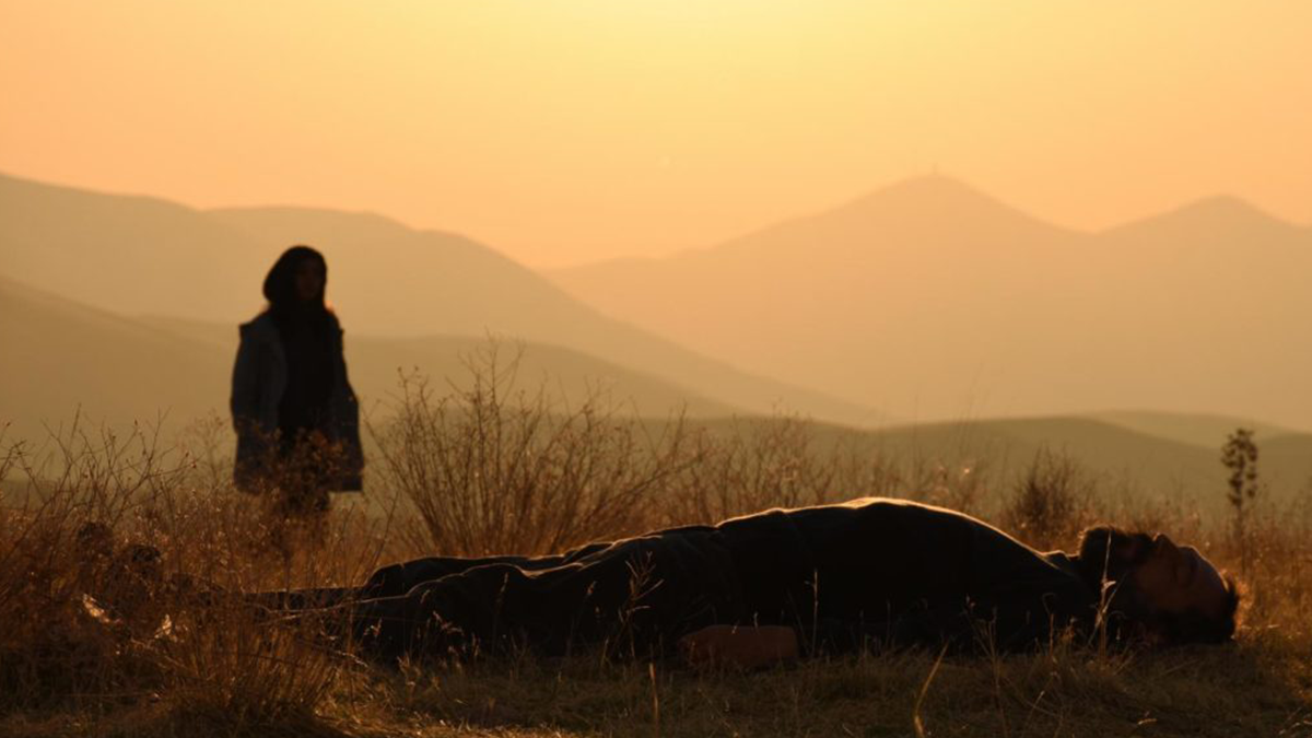 person lying and another persons silhouette in the background