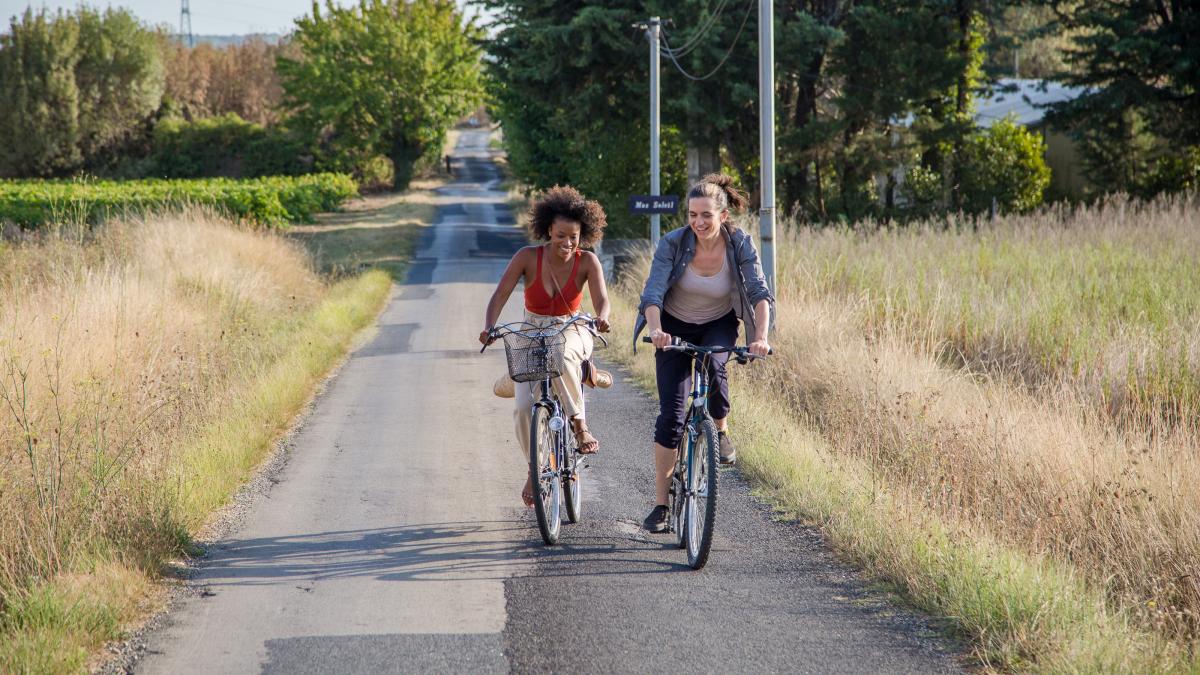 Two people riding bikes on a road