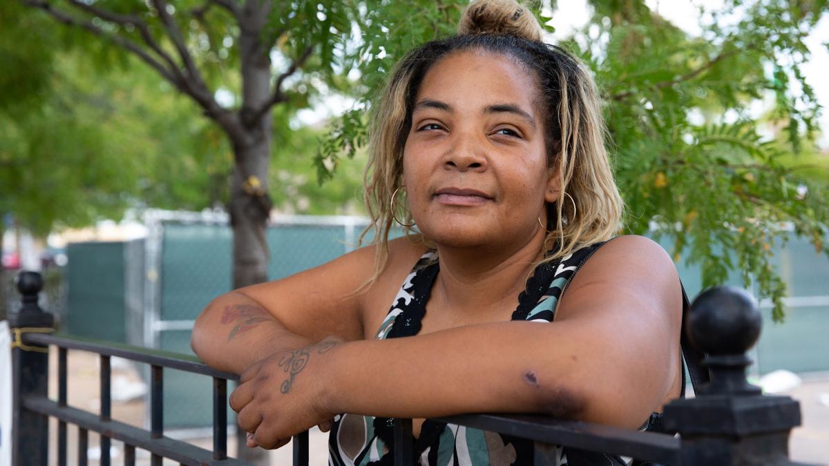 woman leaning on fence smiling