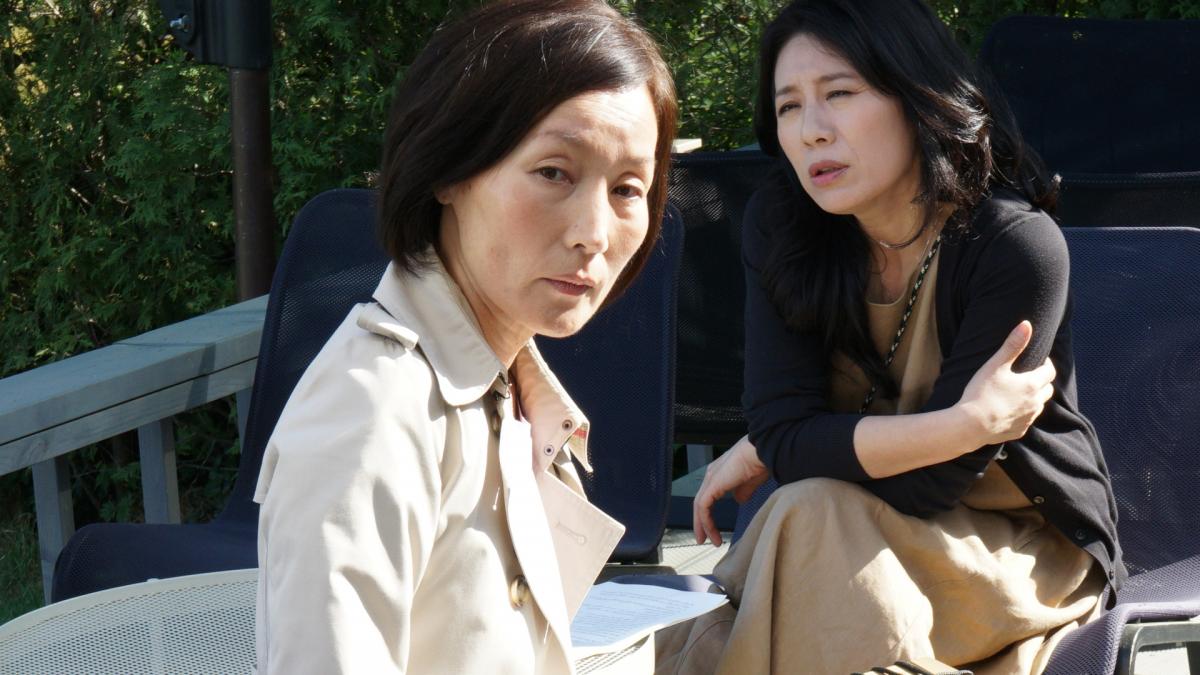 two woman sitting outside 