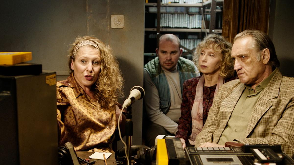 people sitting in radio broadcasting booth