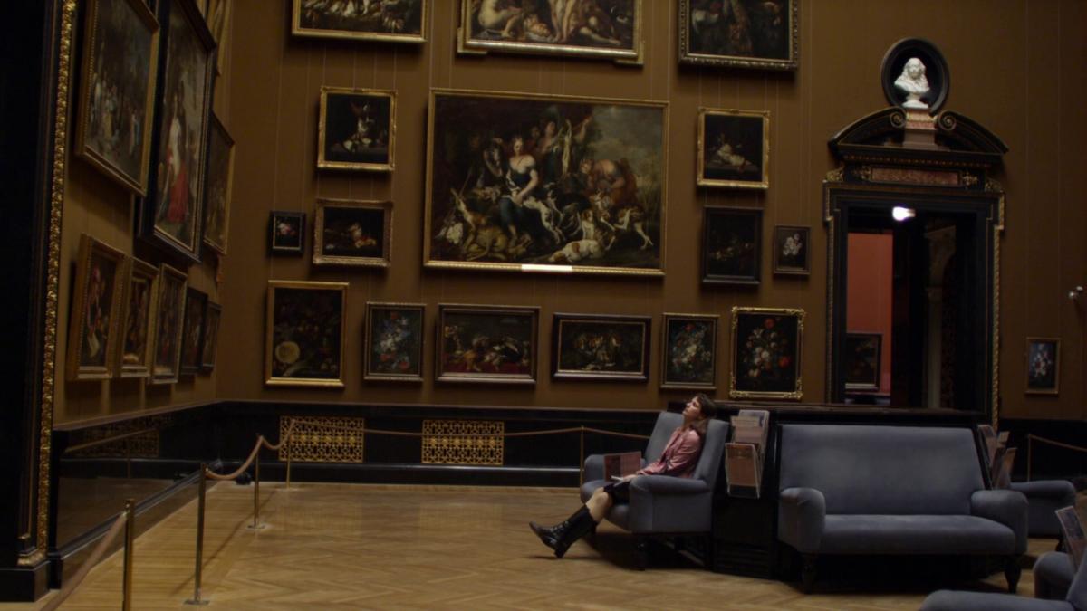 woman sitting on bench in art museum