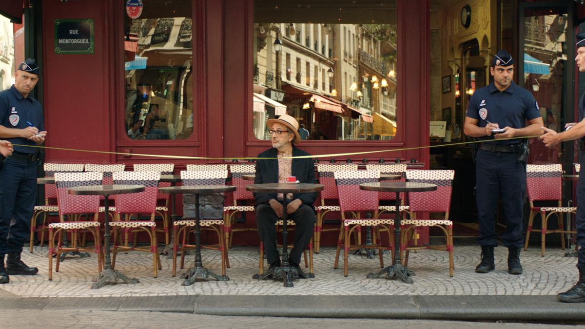 man sitting at cafe with two police