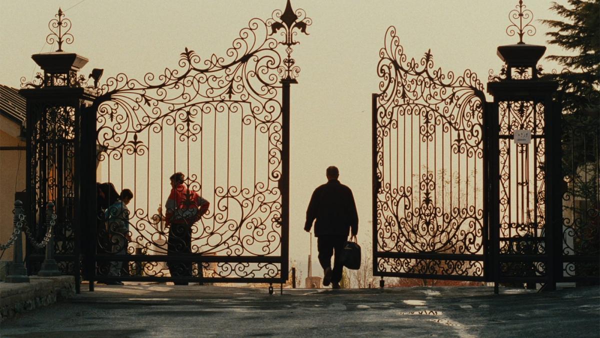 man walking through large ornate gate