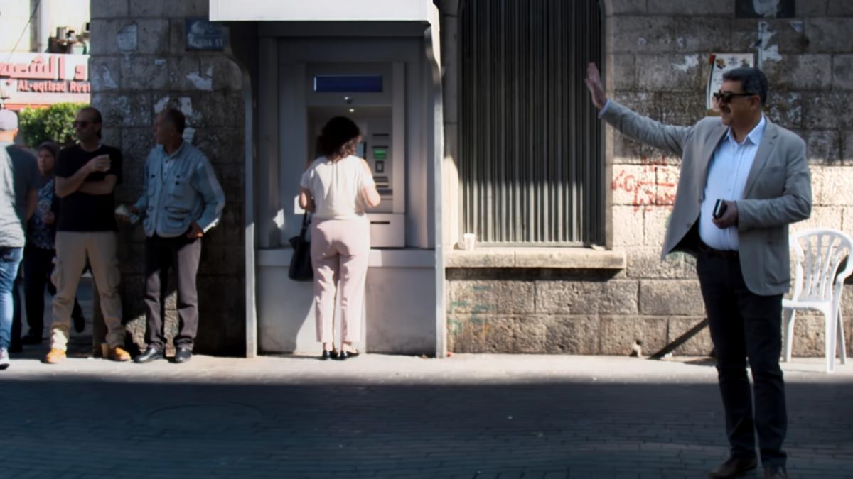 man standing on street waving
