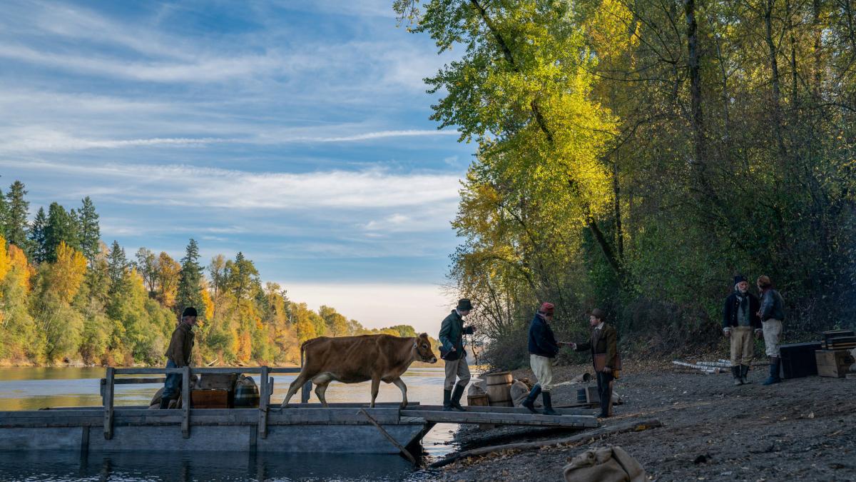 man and cow on lake dock 