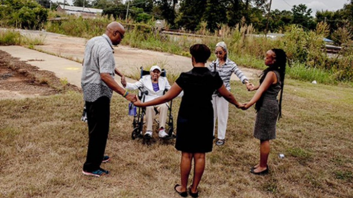 people holding hands in a circle outside
