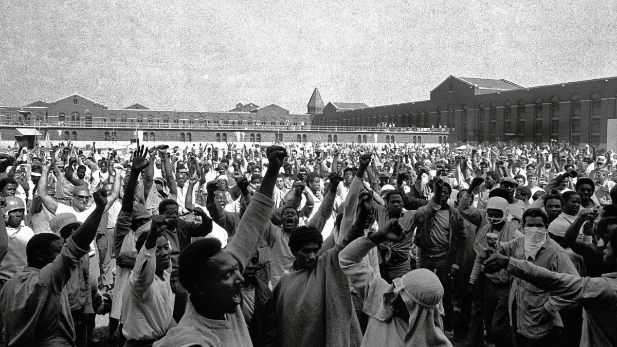 men raising fists in prison yard