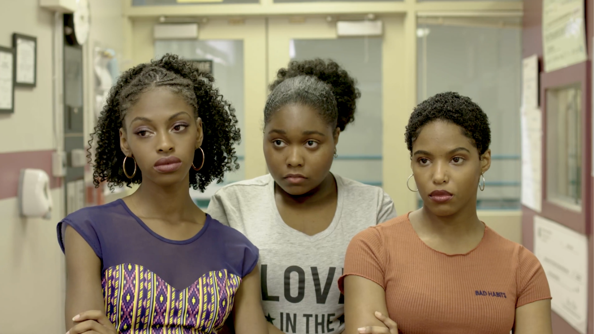 three girls with arms crossed in hallway