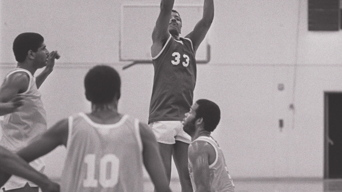 man shooting basketball on court