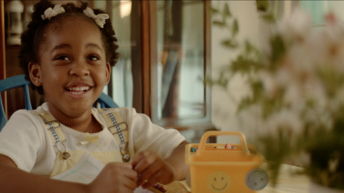 little girl smiling at table