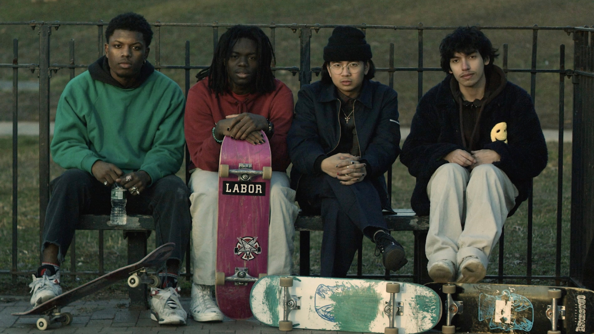teenagers sitting on bench with skateboards