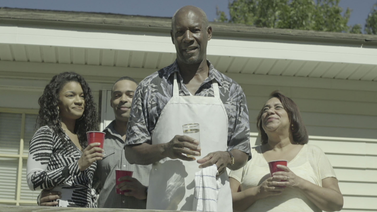 family standing on edge of deck with drinks