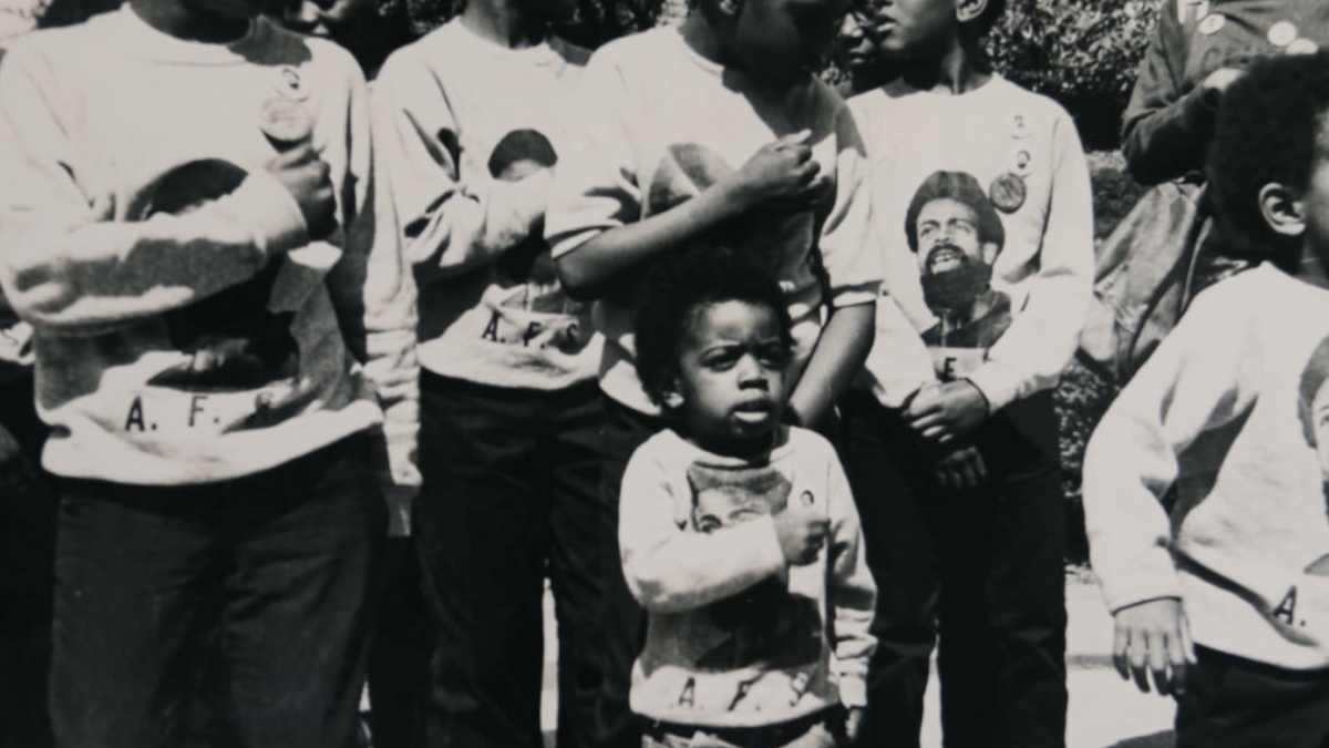 little boy in front of people with hand on heart
