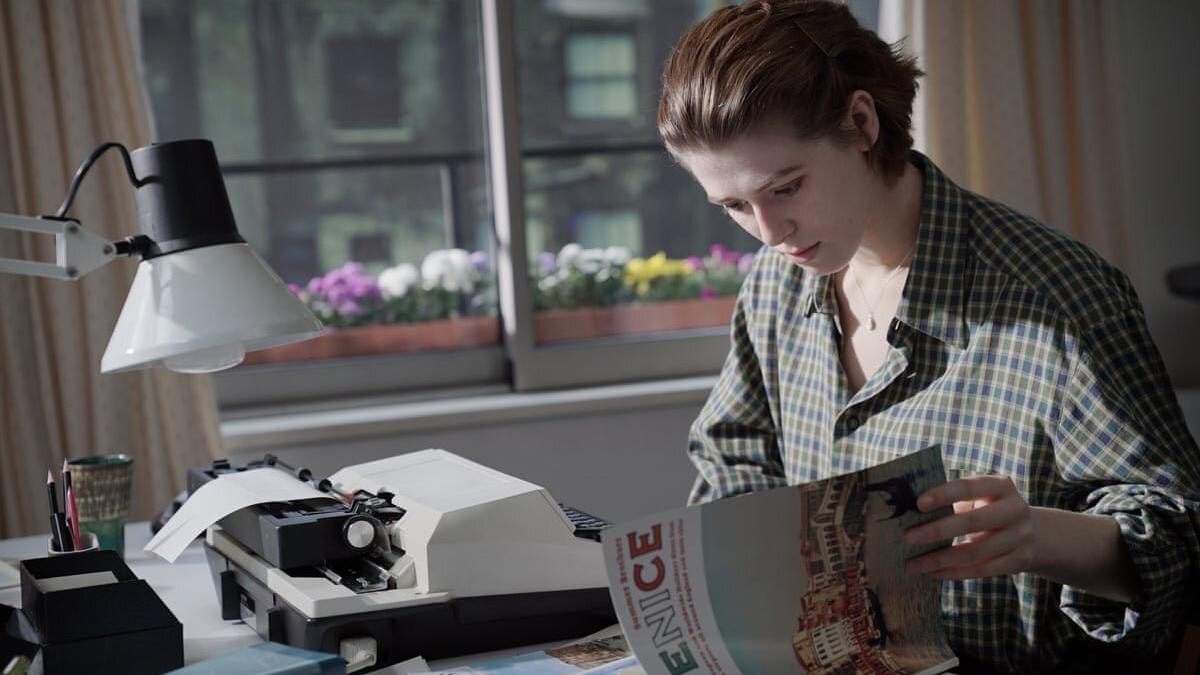 woman at desk looking through papers