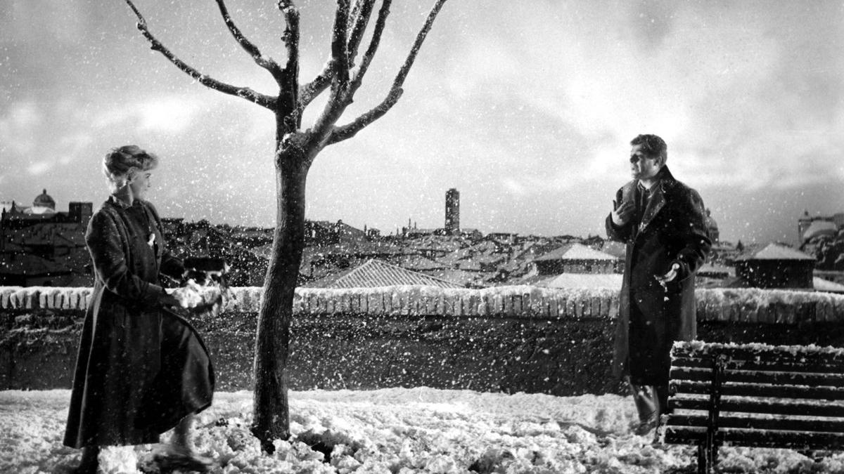 man and woman standing in snow near river