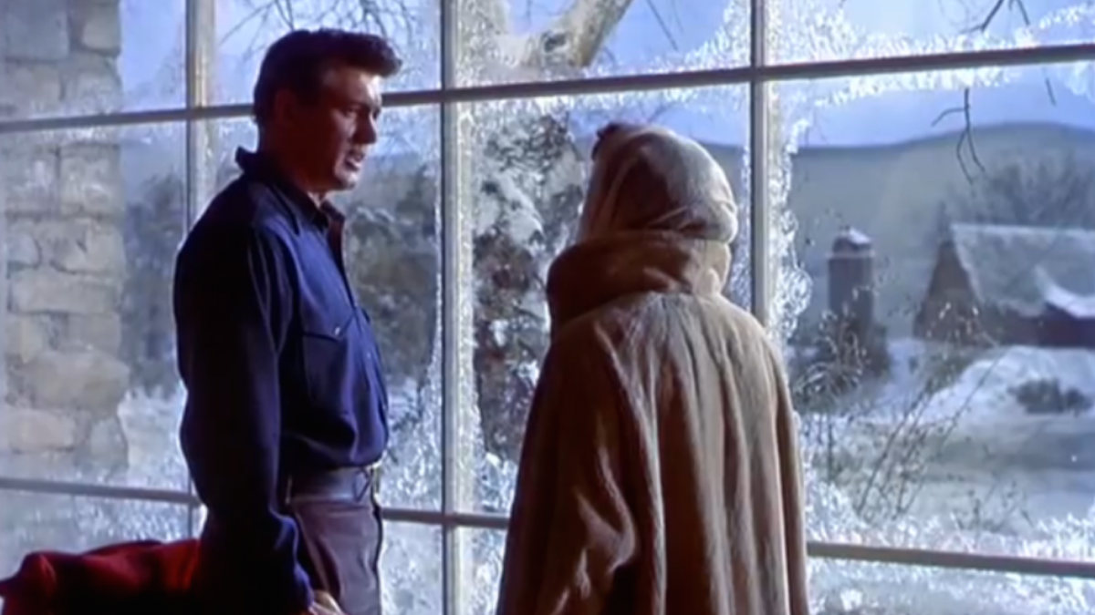 man and woman standing in front of snowy window