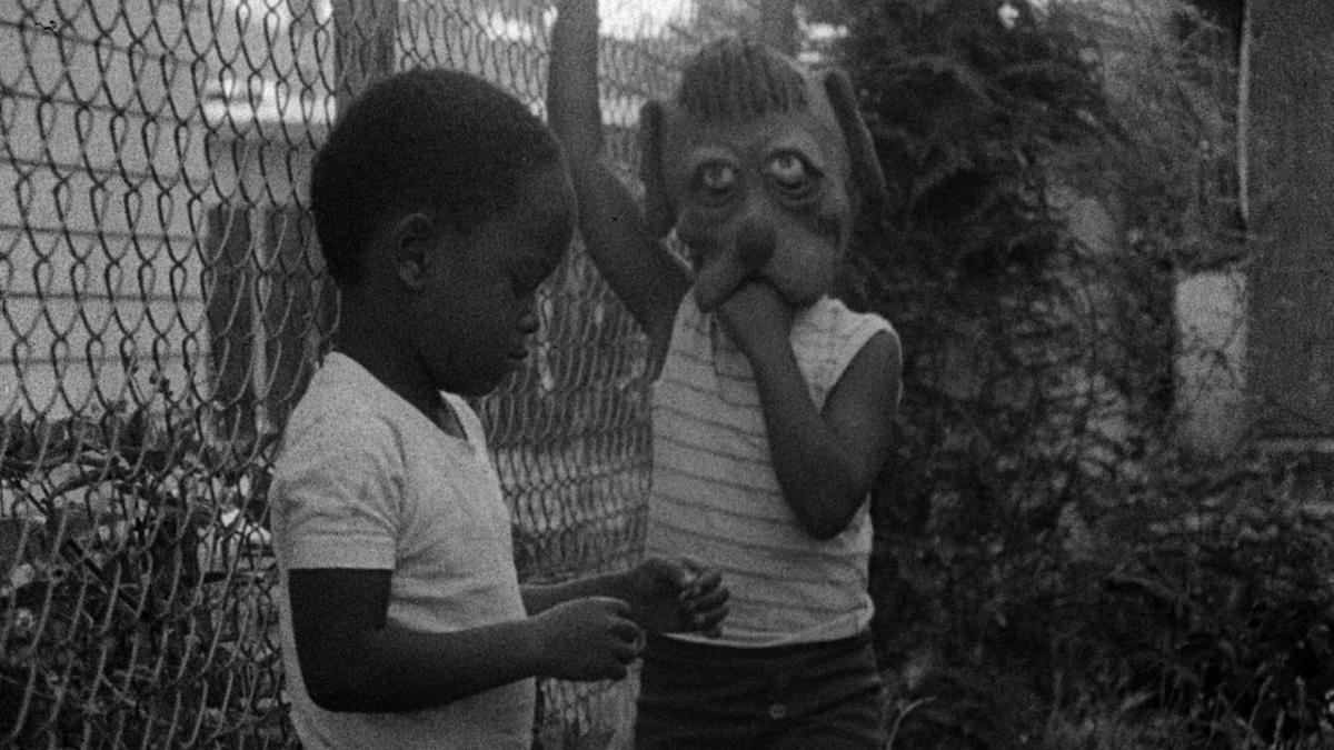 kids by fence with animal costume mask