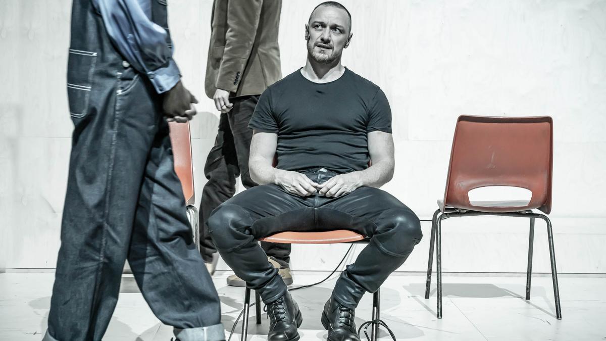 man sitting in chair on stage