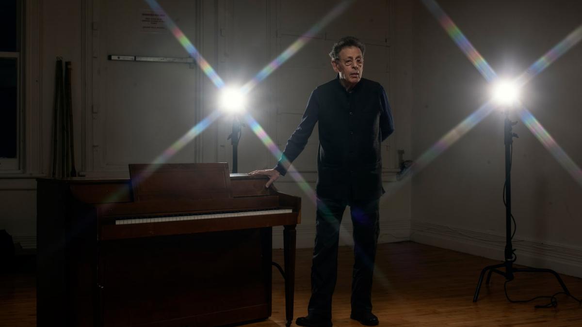 man standing with projector lights behind him