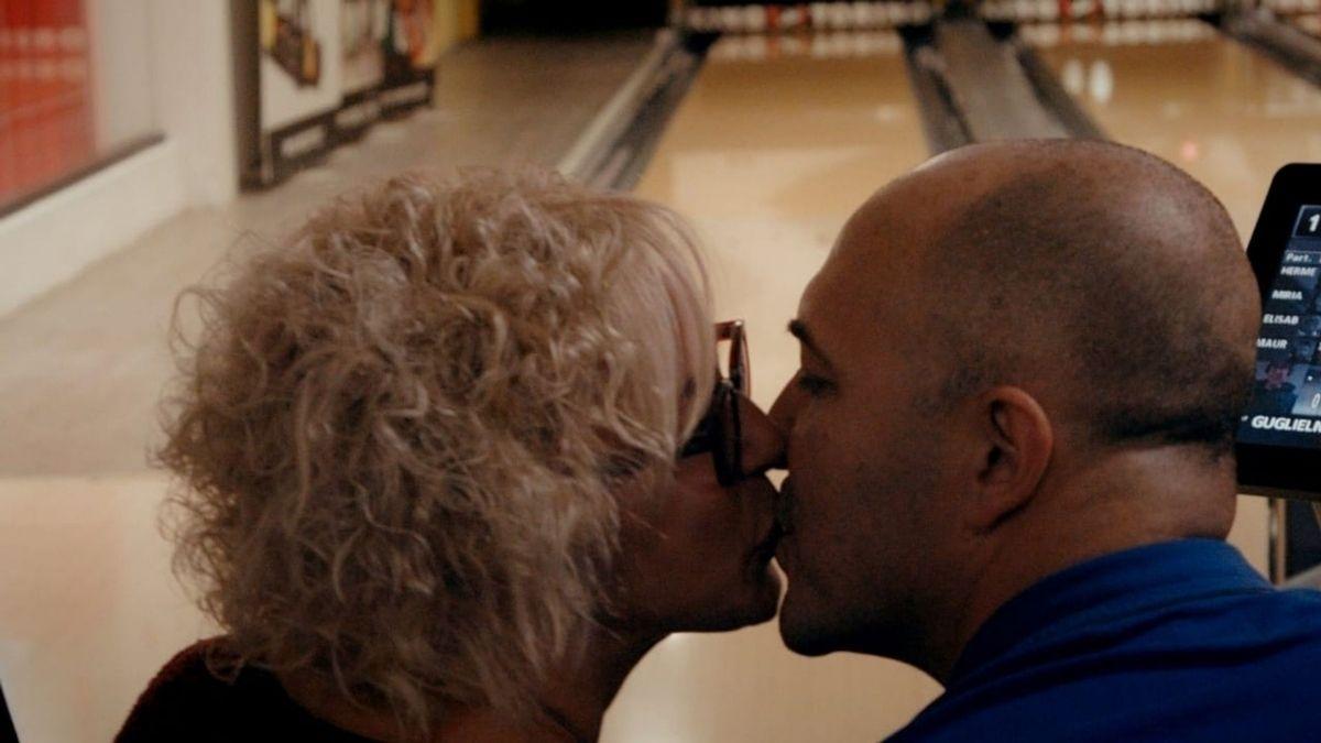 man and woman kissing at bowling alley