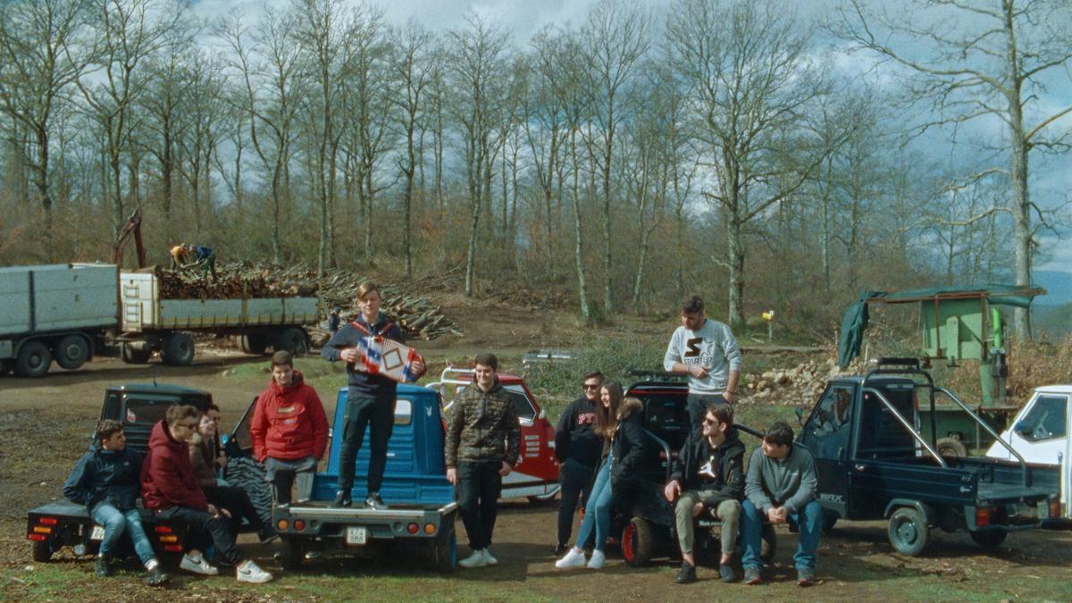 group of people sitting outside on trailers and cars in front of trees