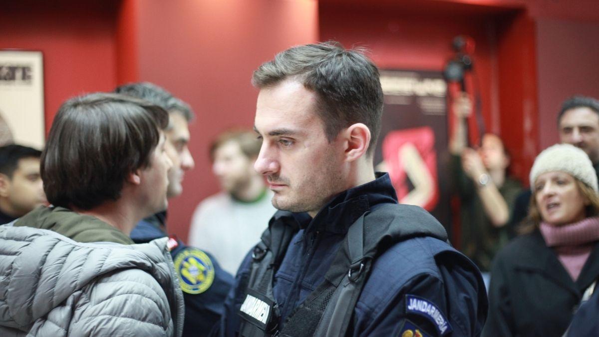 police officer standing in crowd staring blankly