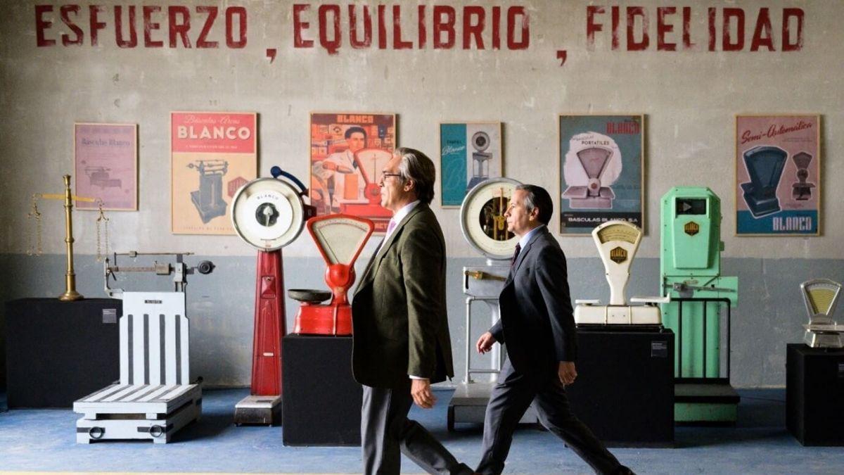 two men wearing suits walking in workplace
