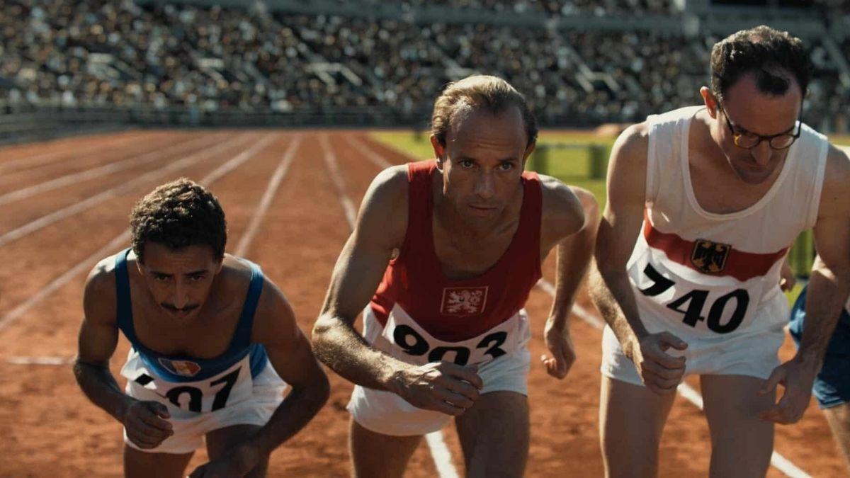three men standing at starting line on a track for a race