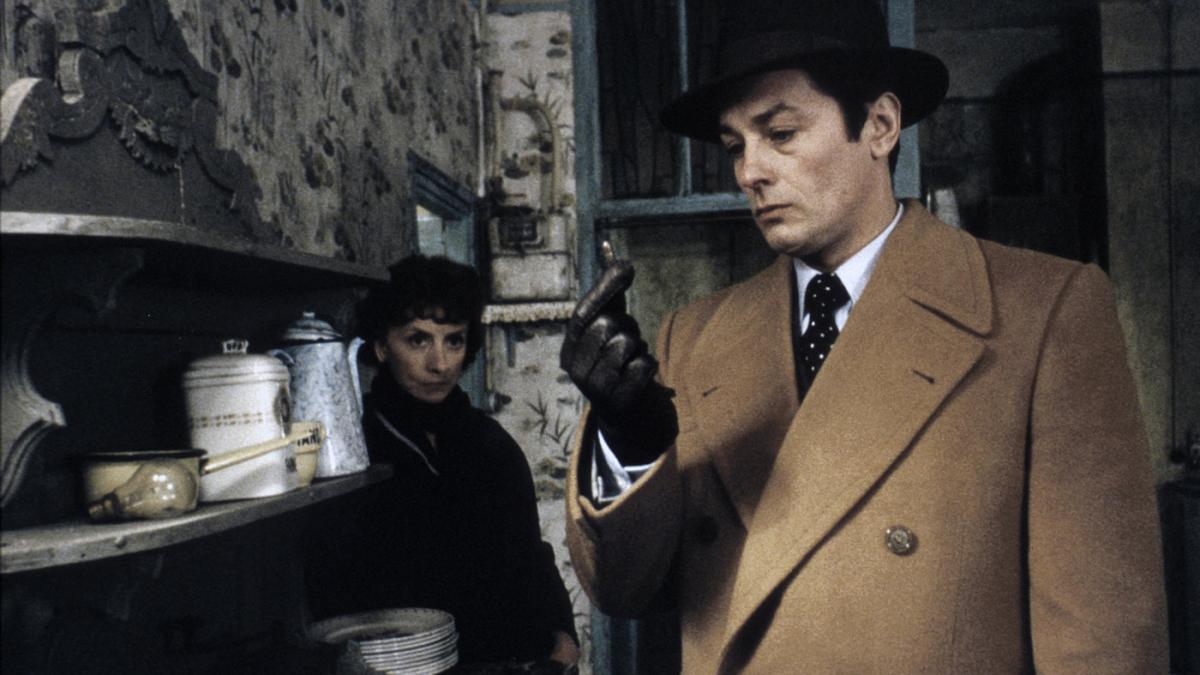 man in trench coat investigating object