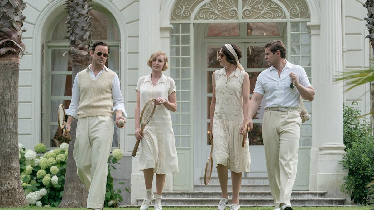 two couples walking on lawn in formal tennis outfits