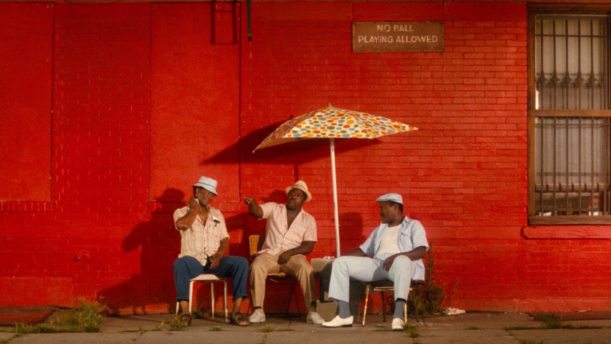 men sitting under umbrella outside 