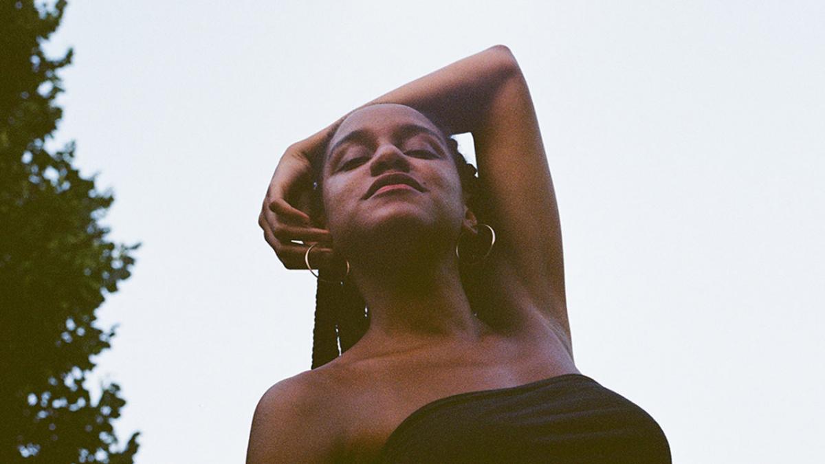 woman from low angle with arm wrapped around head