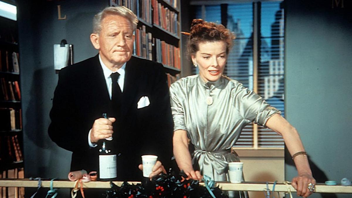 man and woman looking over balcony with champagne and cups