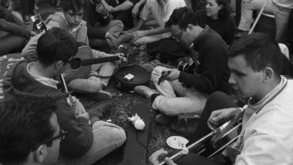 people sitting on ground with string instruments