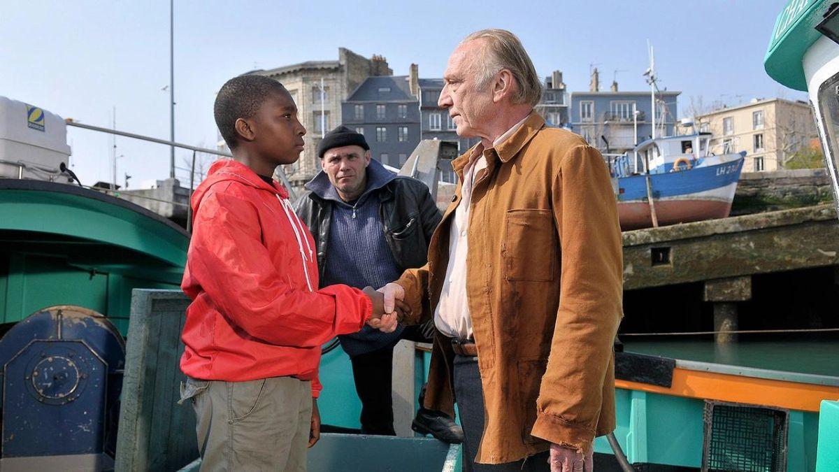 two men shaking hands outside near the sea